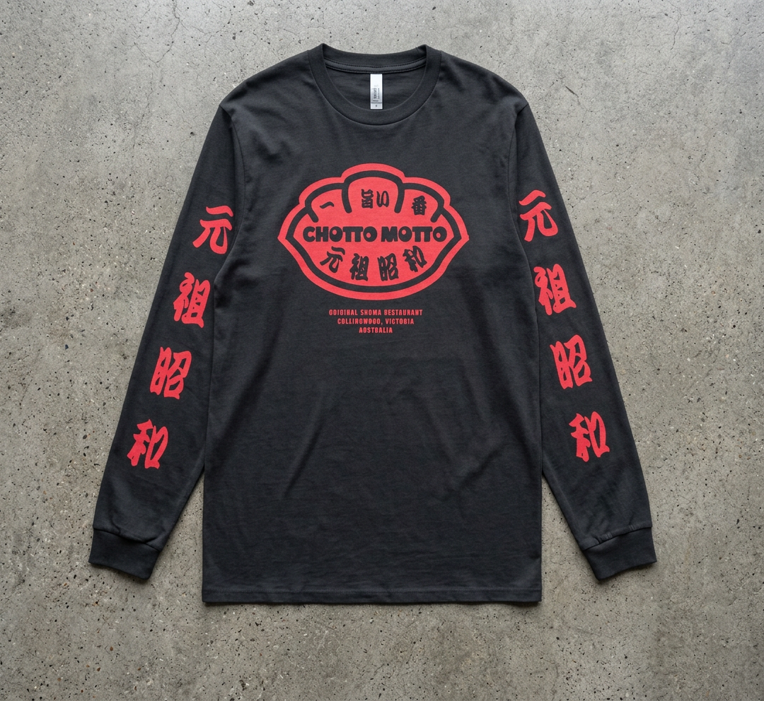 A black long-sleeve graphic t-shirt with red printed designs, laid flat on a textured gray concrete surface. The center features a red and white 'Chotto Motto' graphic, with red Japanese characters printed down both sleeves.